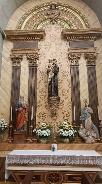 Altar lateral com Santo António e o Menino sobre mísula, entre uma figura de vermelho e azul e uma Nossa Senhora de branco e azul