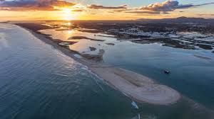 Praia da Ilha da Fuseta com areia branca e mar de cor esmeralda em dia de sol